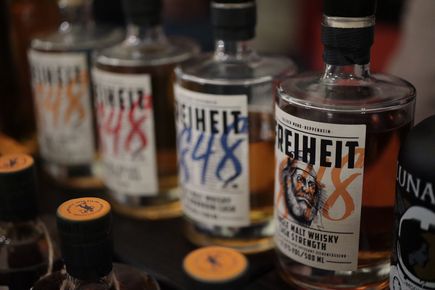 Mehrere Flaschen Freiheit 1848 Whisky stehen aufgereiht nebeneinander 